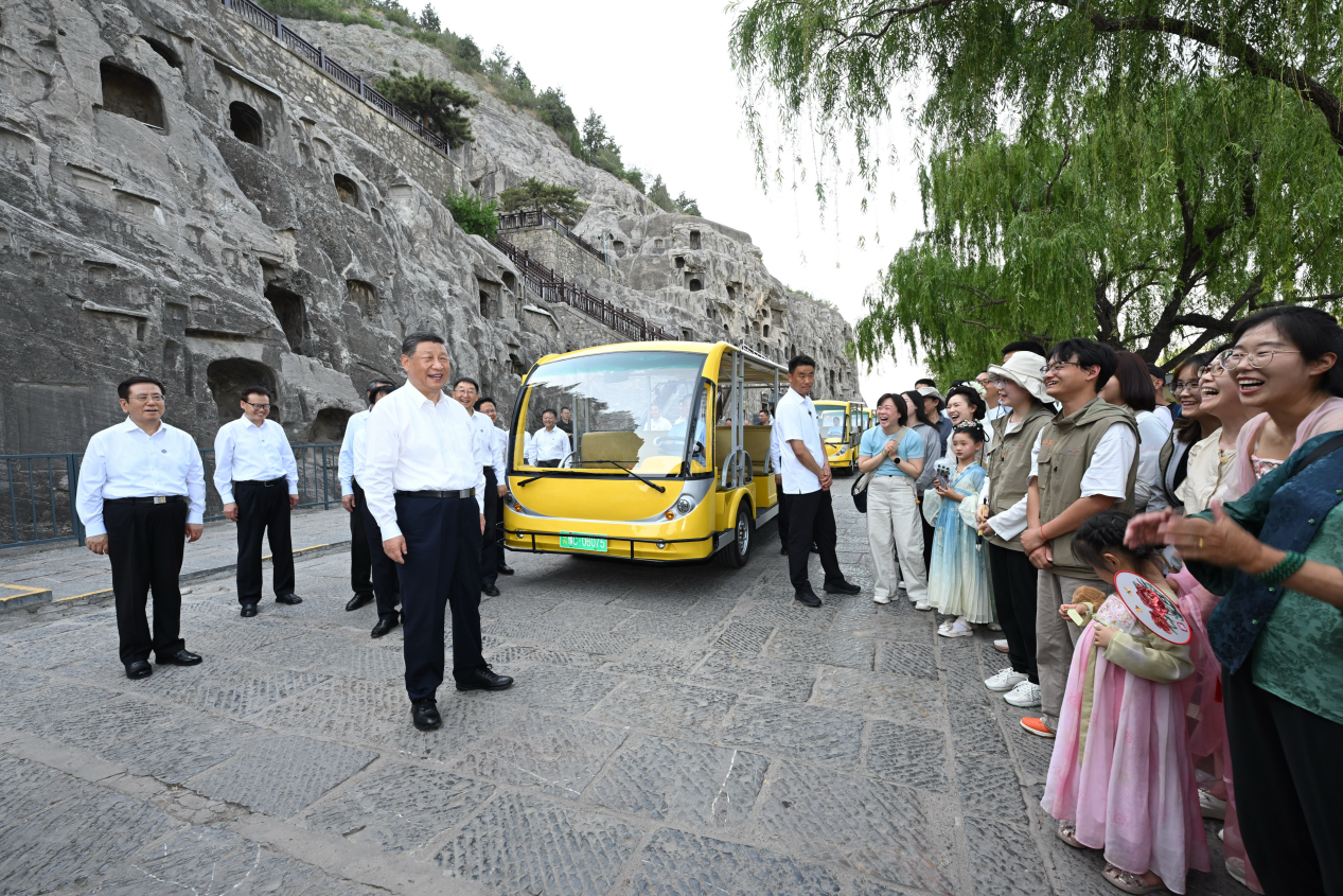 5月19日,習近平在洛陽龍門石窟考察時,同游客親切交流。