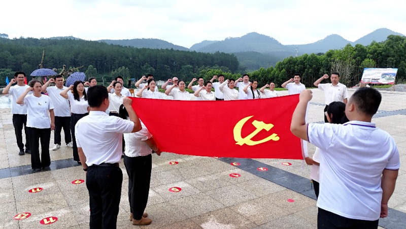 2025年7月1日，廣西都宜忻人民解放總隊紀念館前，黨員面向黨旗重溫入黨誓詞。